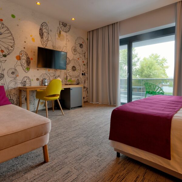 Elegáns, világos függöny modern hotel jellegű hálószobában, mintás fallal és élénk színekkel.